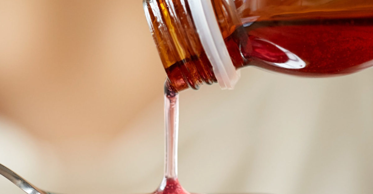 Liquid medicine being measured into a spoon